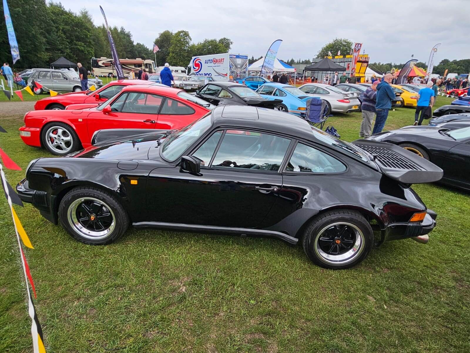 Black Porche 911 Turbo exhibited at a classic car show.