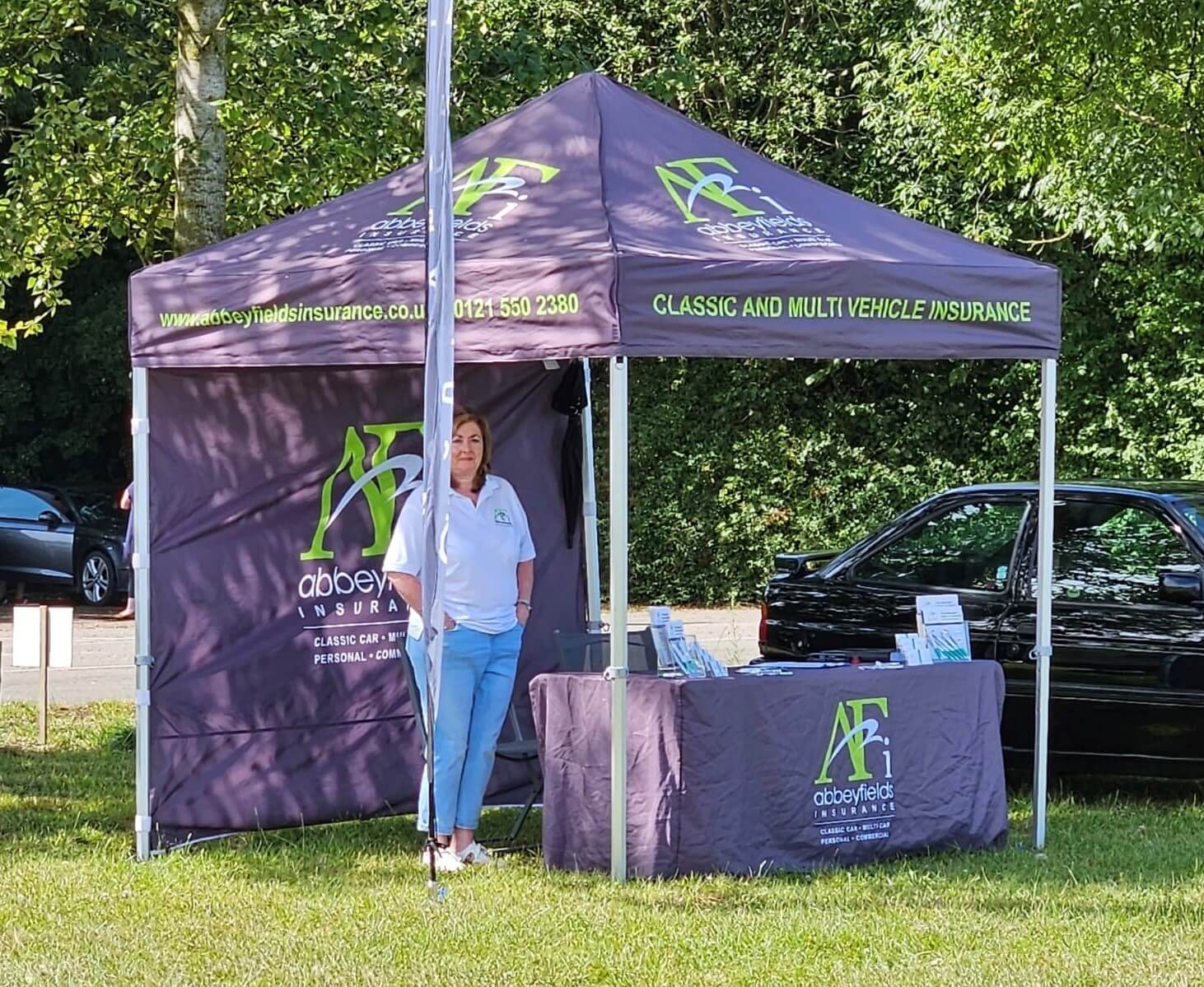 Jayne Jordan, an Abbeyfields Insurance employee standing inside the Abbeyfields Insurance stand exhibiting at a classic car show